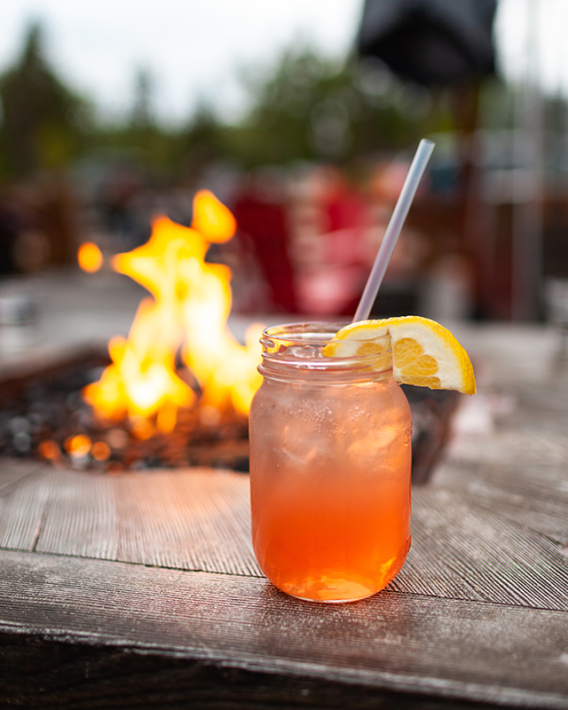 fruity drink next to an outdoor fire table